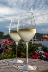 Tasting of local white wine in summer with sail boats haven of Port Grimaud on background, Provence, France