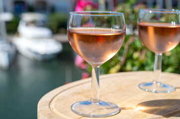Tasting of local rose wine in summer with sail boats haven of Port Grimaud on background, Provence, France