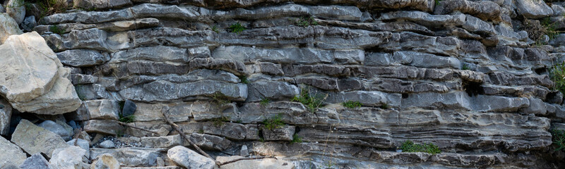 Natural wavy rocky formation along the river. Abstract rough natural background