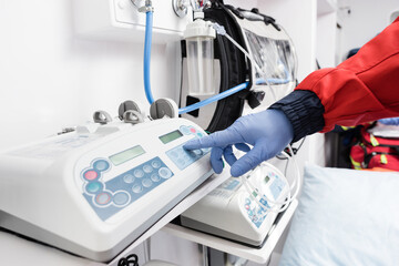 Cropped view of paramedic in latex glove using equipment in ambulance auto