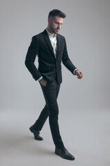 Thoughtful elegant man holding hand in pocket and looking down