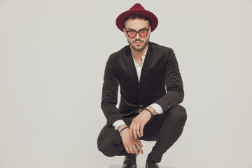 Confident fashion model looking forward while crouching