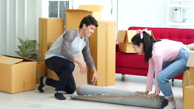 couple young Asian man and woman moving big box in the house. real estate concept. new normal concept.