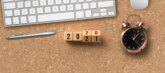 office equipment and cubes turning from year 2020 to 2021 on cork background