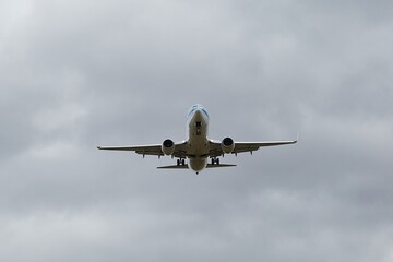 Fototapeta na wymiar Plane approaching landing in cloudy overcast weather
