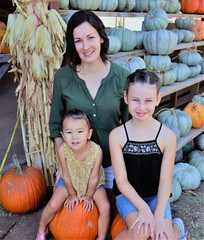 Fototapeta premium Mother and kids with pumpkins at the pumpkin patch 