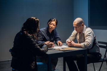 In the police station's interrogation room, good and bad cops are questioning a theft suspect in a leather jacket