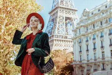 Happy, smiling fashionable woman wearing stylish autumn outfit: orange hat, dress, green velvet...