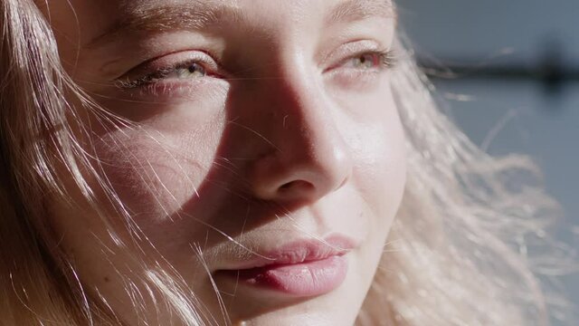 Face attractive blond woman at sunset smiling beautiful around green eyes. Stand outdoor relax. Happy relax. Close up. Slow motion.