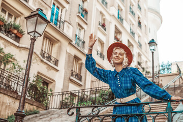 Obraz na płótnie Canvas Happy, smiling tourist woman wearing stylish autumn blue checkered dress, orange hat, wide white belt, posing in street of Paris. Copy, empty space for text