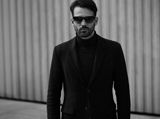 Fashion beard style business handsome man posing in style clothing and trendy sun glasses on street wall outdoors background. Closeup