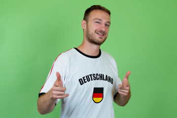 Männlicher Deutschland Fan freut sich aufs Spiel grünem Hintergrund