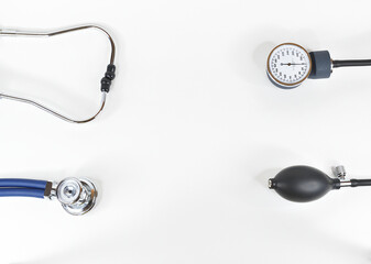 Top view of the components of a stethoscope. Acoustic head, headband tubes, pressure gauge and blower isolated on white background.