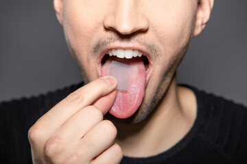 man takes breath stripes on his tounge that refreshes breath in mouth, removes smell and kills...