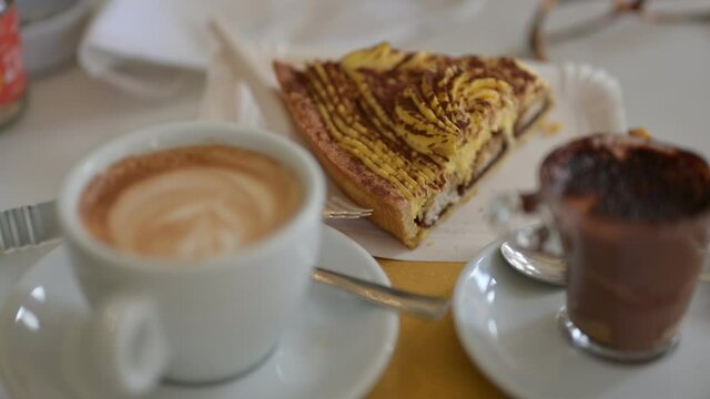 Footage pan on a tray with a cappuccino, a Moroccan and a slice of tiramisu cake. Selective focus. Concept of escape and food release from the discomfort of the COVID era