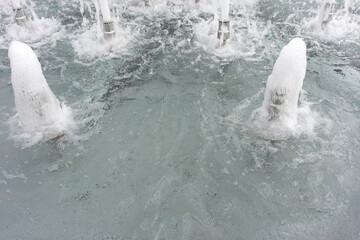 Water and spray in the city fountain. Transparent stream of water.