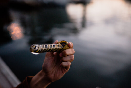 Hand holding a pipe over the water