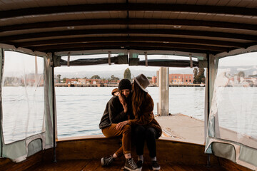 Lesbian couple cuddling on boat