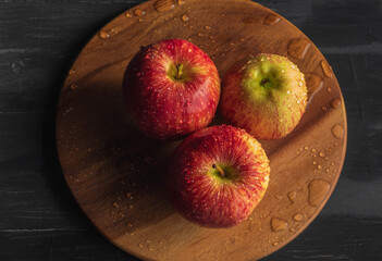 View from above on three fresh and juicy apples with drops of water