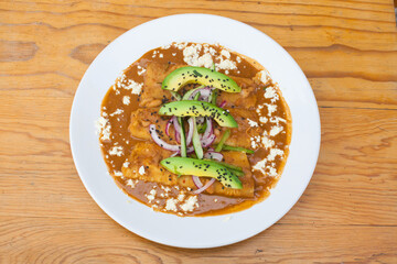 plato con enchiladas en salsa roja, salsa de frijoles