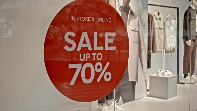 text on the red sticker on the glass of window in the store with the inscription sale up to 70% off