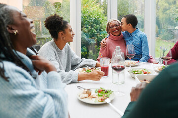 Girl kissing her grandma during dinner