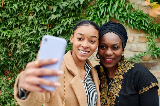 Muslim mom and daughter taking selfies