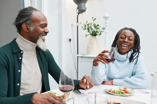 Laughing couple having wine with dinner