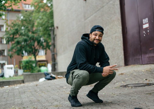 Portrait Of Young Man Kneeling In Street