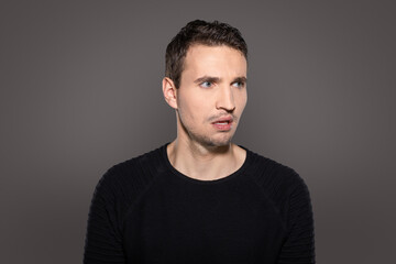outraged man look to side isolated on grey background
