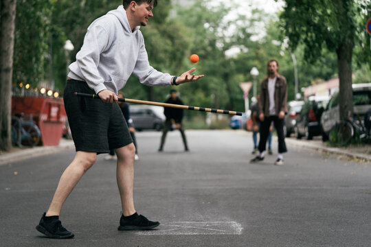 Young Man About To Serve Ball During Game Of Stickball