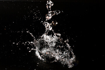 Splash of clear water on black isolated background.