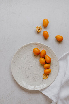 Kumquats on light background