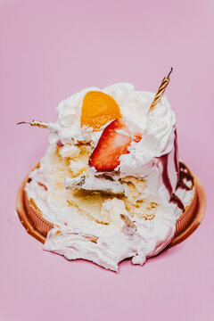 creamy birthday cake destroyed and golden candle