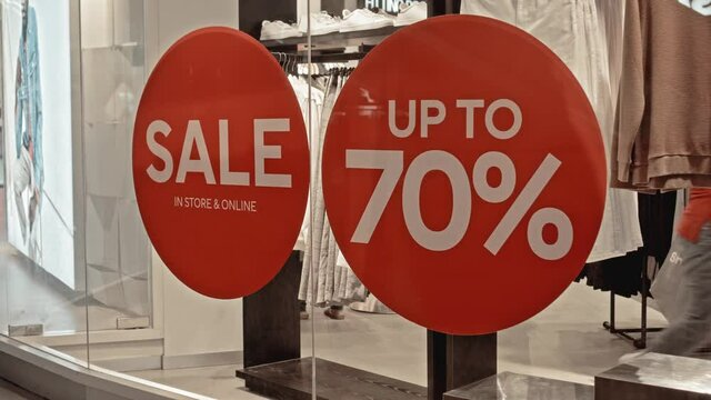 text on the red sticker on the glass of window in the store with the inscription sale up to 70% off