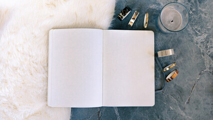 mockup  of blank notebook on cosy lamb fur on grey textured stone background
