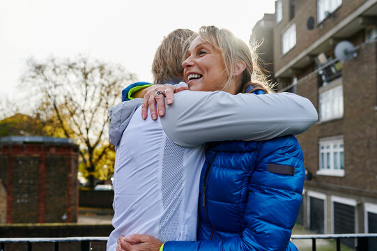 Two friends hugging after a run