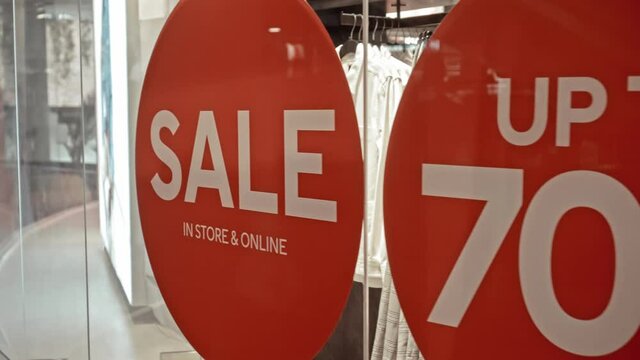 text on the red sticker on the glass of window in the store with the inscription sale up to 70% off