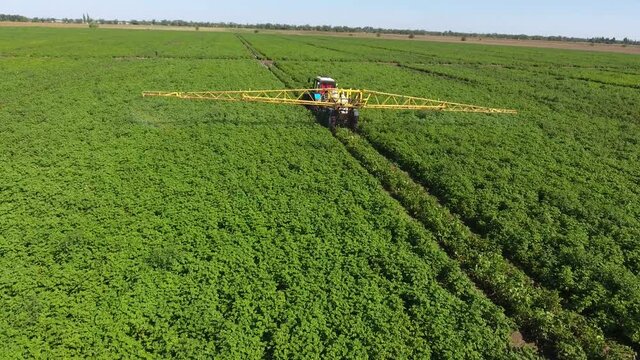 Aerial shot of powerful tractor pulling barrel with water and irrigation installation