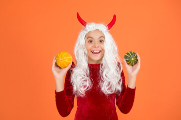amazed devil teenage girl with white hair hold pumpkin vegetable wear horns costume of imp on...