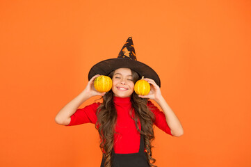 happy girl in witch hat costume to halloween with small yellow pumpkin, halloween jack o lantern