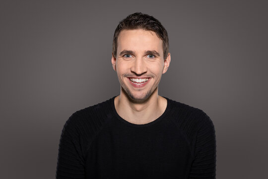 humorous happy man laughing intro camera with open mouth showing his teeth while reacting to funny situation