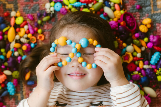 Little girl playing with beads