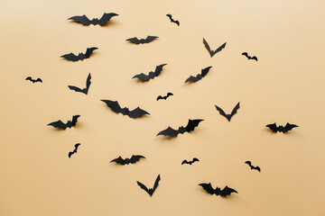 Halloween decorations with bats on pastel beige background. Halloween concept. Flat lay, top view, copy space