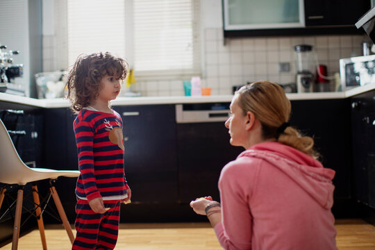 Two year old boy with his mother eating potato chips