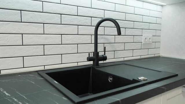Kitchen sink and faucet. Simple well designed modern white wooden kitchen interior. Dolly camera move 4k