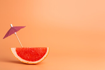 Grapefruit slice on a orange background. Summer, vacation and travel minimal concept.