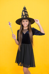 happy witch teenage girl with magic wand wear costume of wizard on halloween party, halloween