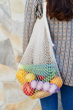 Woman carrying a bag of fresh vegetables