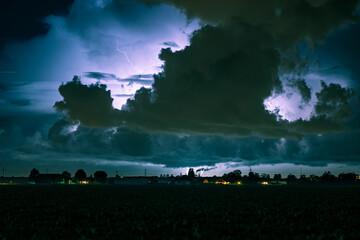 Storm clouds at night with distant lightning strikes